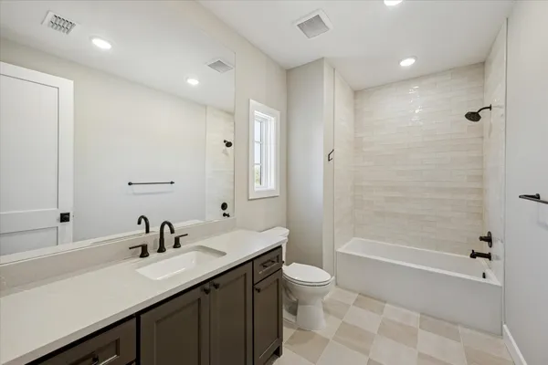 a bathroom with a double vanity sink toilet mirror and bathtub