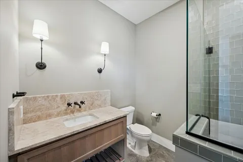 a bathroom with a granite countertop sink a toilet and shower