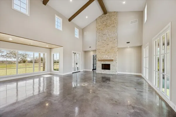 an empty room with windows and fireplace