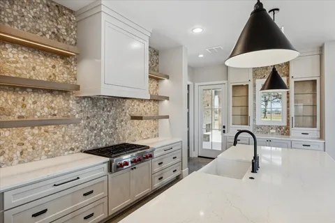 a kitchen with stainless steel appliances kitchen island a white counter space and a window