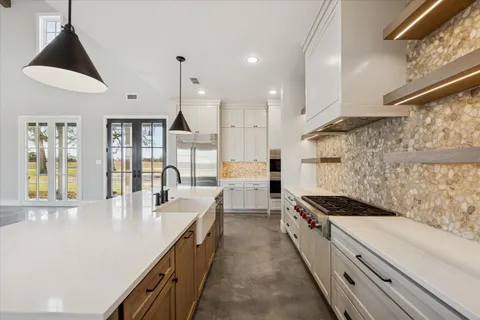 a kitchen with kitchen island a counter space a sink a stove and a window