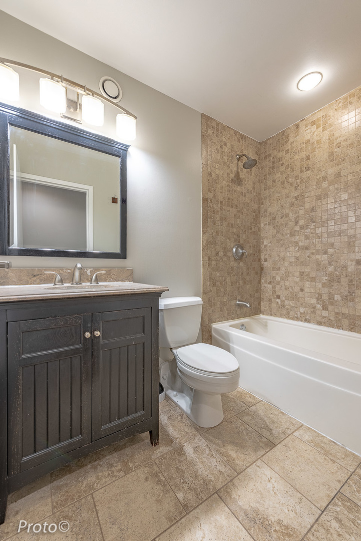 20 North State Street, Unit 1012 Chicago, IL 60602 - Photo 23 of 26 a bathroom with a toilet a sink a mirror a bathtub and vanity