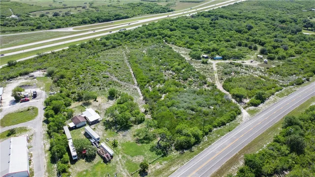 an aerial view of residential houses with outdoor space and trees