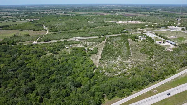 an aerial view of residential houses with outdoor space and trees