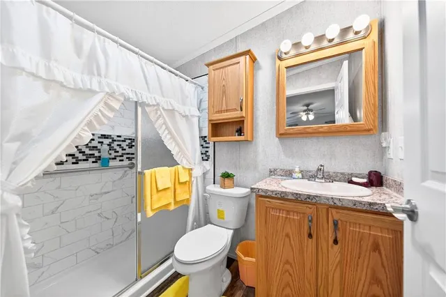 a bathroom with a granite countertop toilet sink and mirror