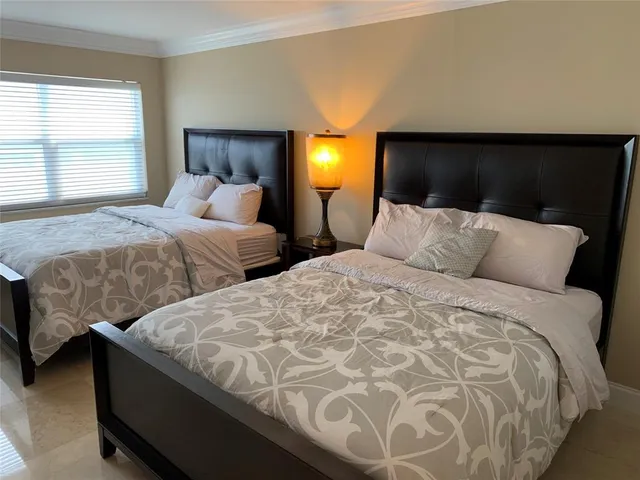 a bedroom with two beds and a lamp with window