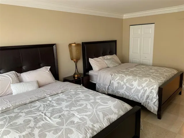 a bedroom with two beds and a night stand