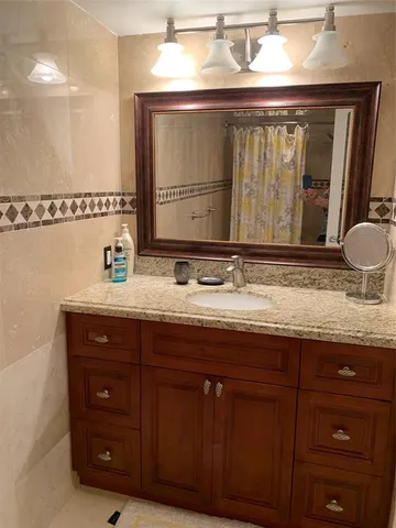 a bathroom with a granite countertop sink and a mirror