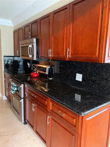 a kitchen with stainless steel appliances granite countertop a sink stove and cabinets