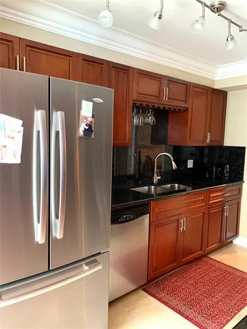 a kitchen with stainless steel appliances granite countertop a refrigerator and a sink