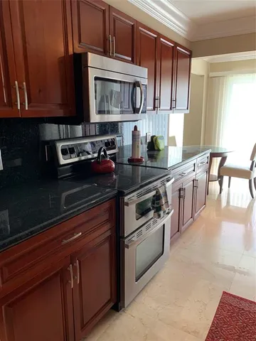 a kitchen with stainless steel appliances granite countertop a stove a sink and a microwave