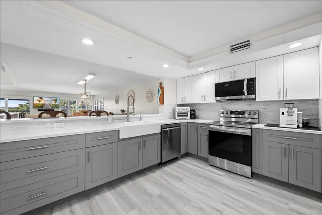 a kitchen with stainless steel appliances kitchen island granite countertop a stove a refrigerator and a dining table with wooden floor