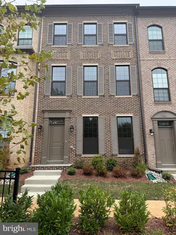 front view of a brick house with a yard