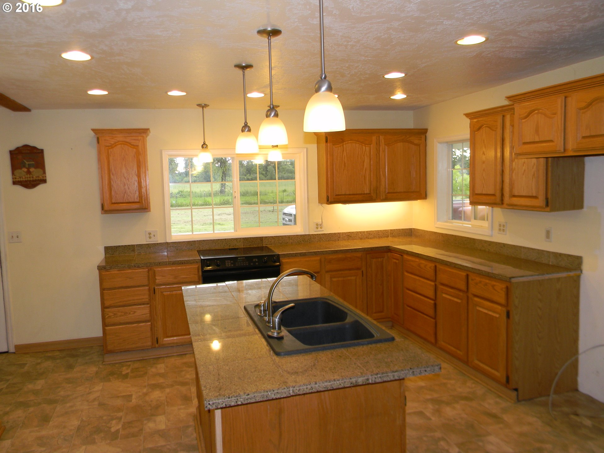 83442 Rodgers Road Creswell, OR 97426 - Photo 6 of 27 a kitchen that has a sink a microwave oven a stove and a counter top space
