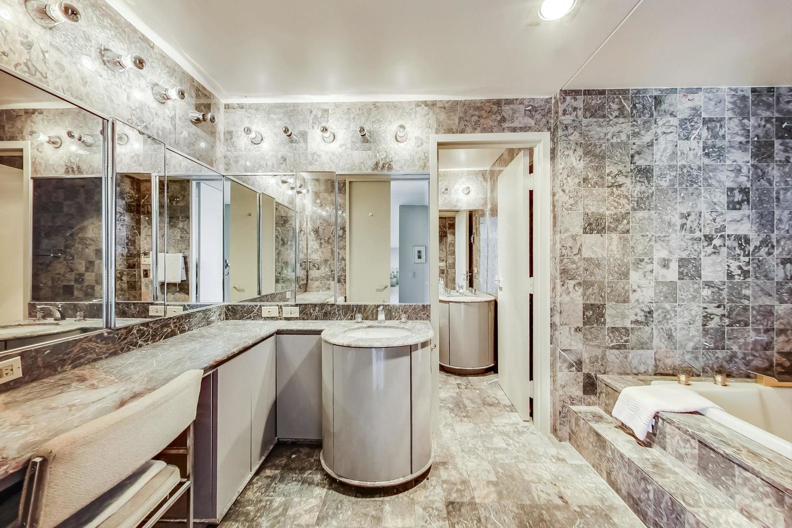 2800 North Lake Shore Drive, Unit 4216 Chicago, IL 60657 - Photo 21 of 29 a large bathroom with a tub sink and mirror