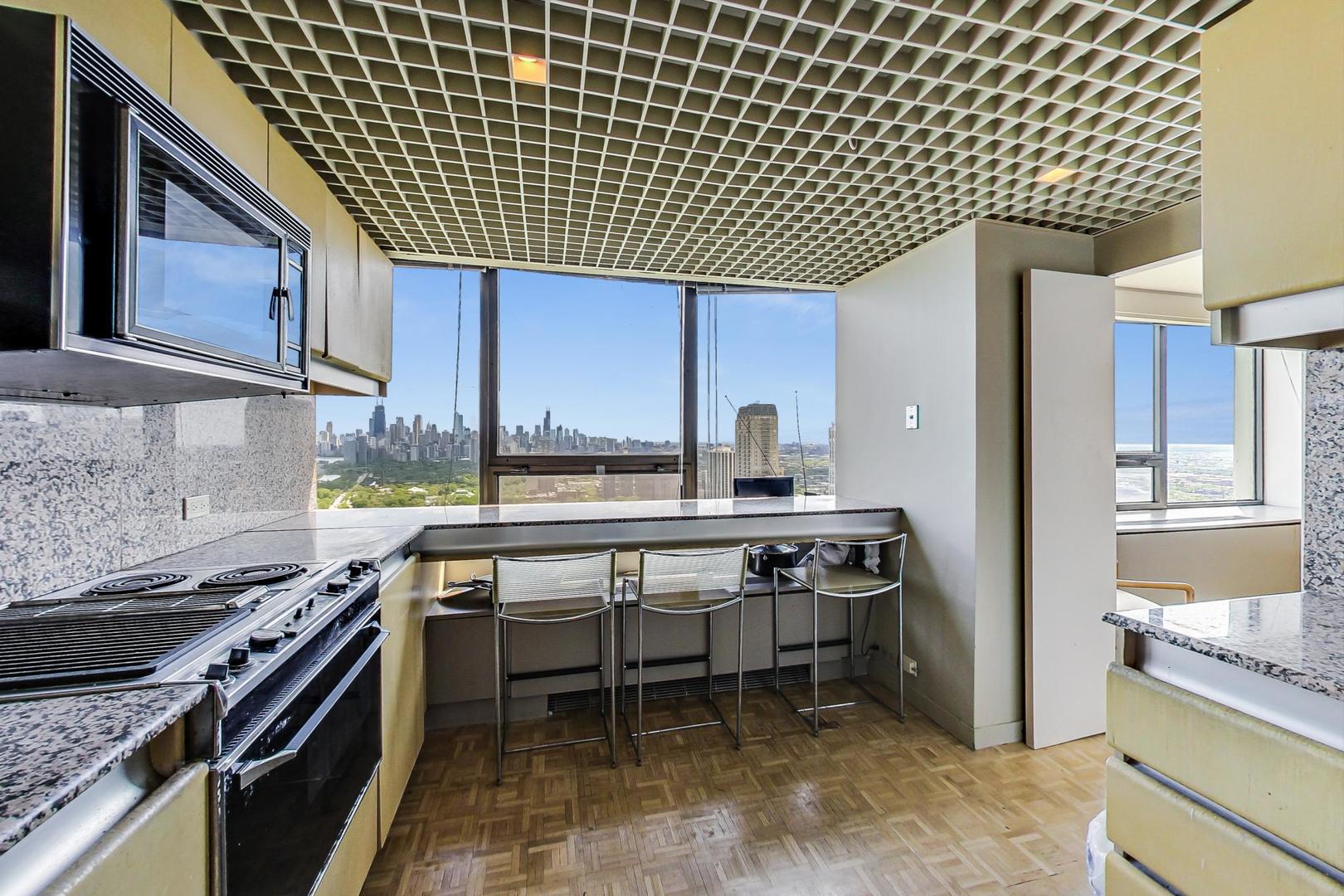 2800 North Lake Shore Drive, Unit 4216 Chicago, IL 60657 - Photo 10 of 29 a kitchen with a stove a sink and cabinets