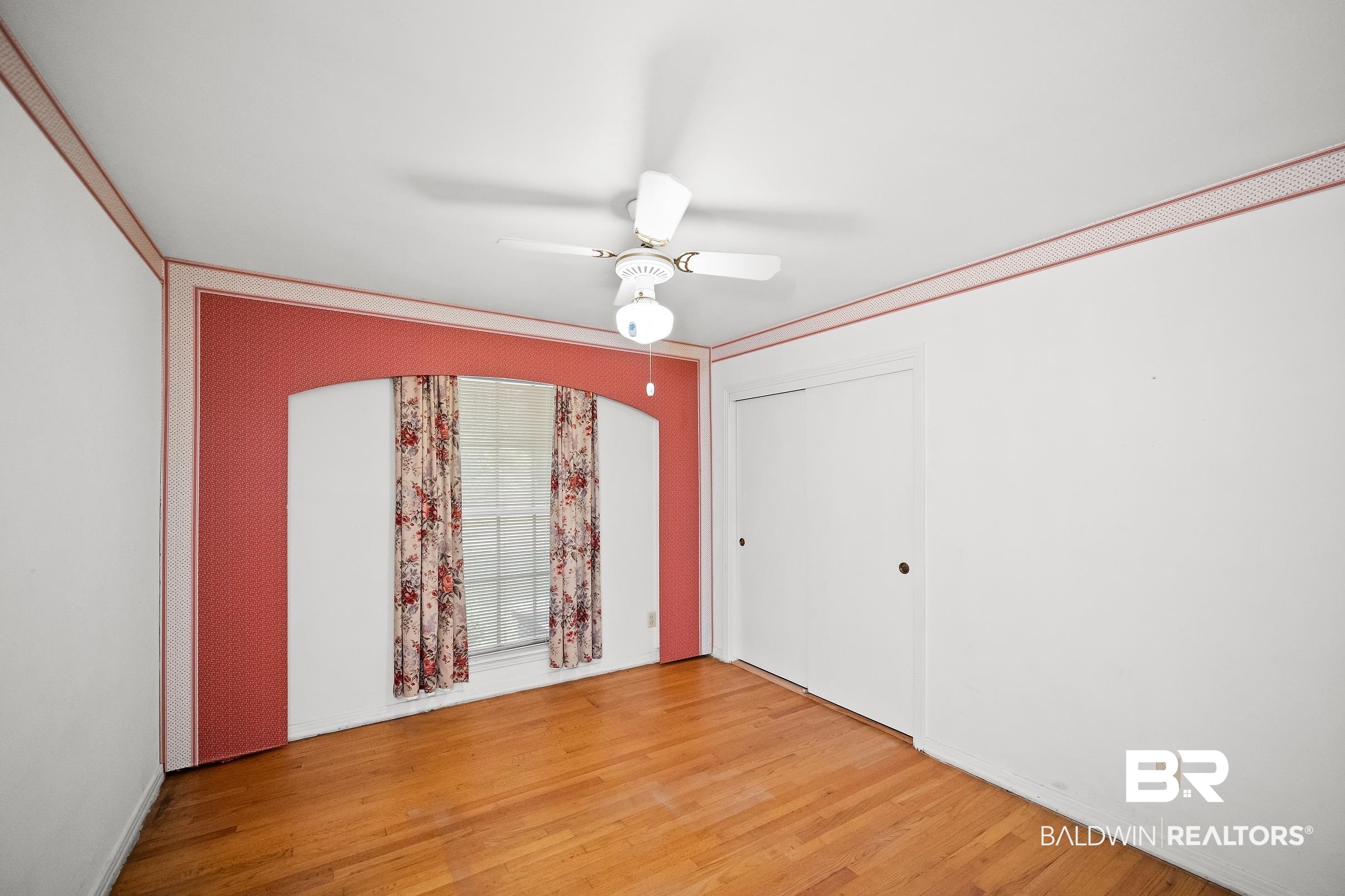 135 Pineridge Road Daphne, AL 36526 - Photo 9 of 19 Room featuring wood-finish flooring, a ceiling fan with light fixture, and a window with arched detailing