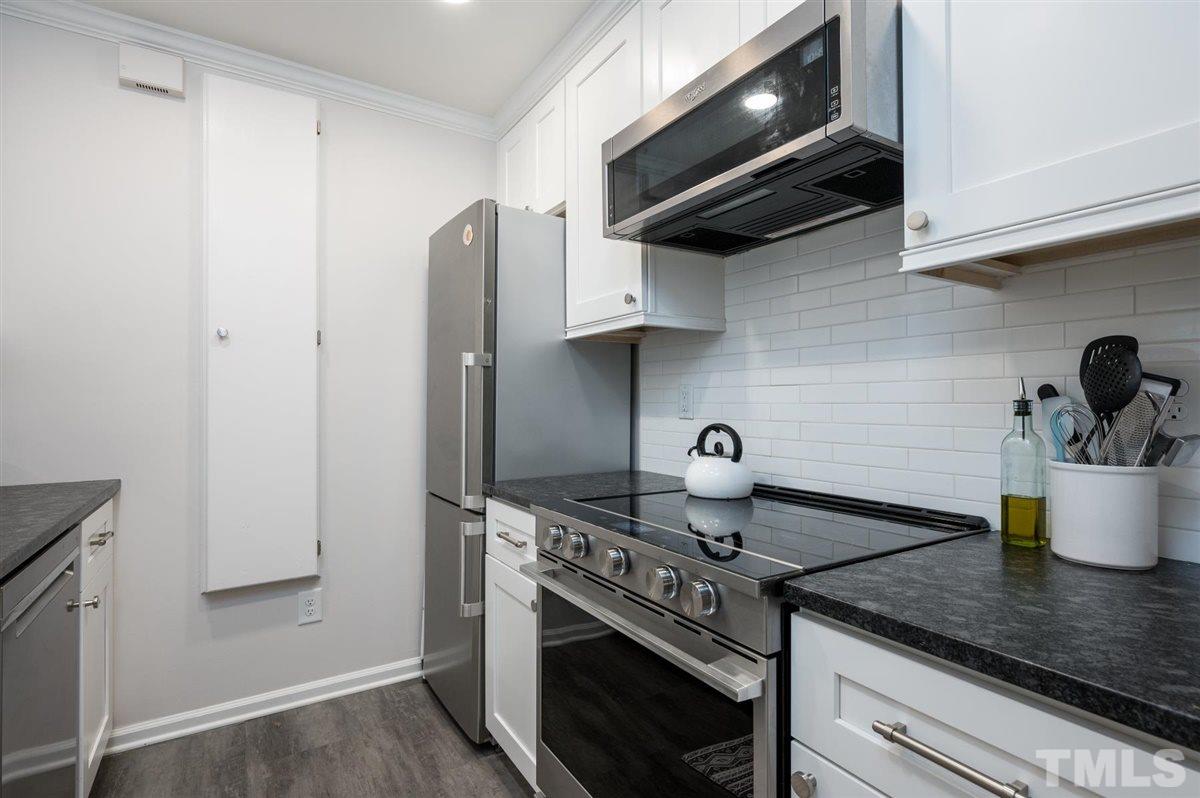 3245 Mill Run, Unit 3245 Raleigh, NC 27612 - Photo 11 of 24 a kitchen with stainless steel appliances granite countertop a sink stove and refrigerator