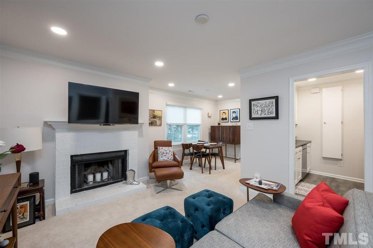 3245 Mill Run, Unit 3245 Raleigh, NC 27612 - Photo 5 of 24 a living room with furniture a fireplace and a flat screen tv