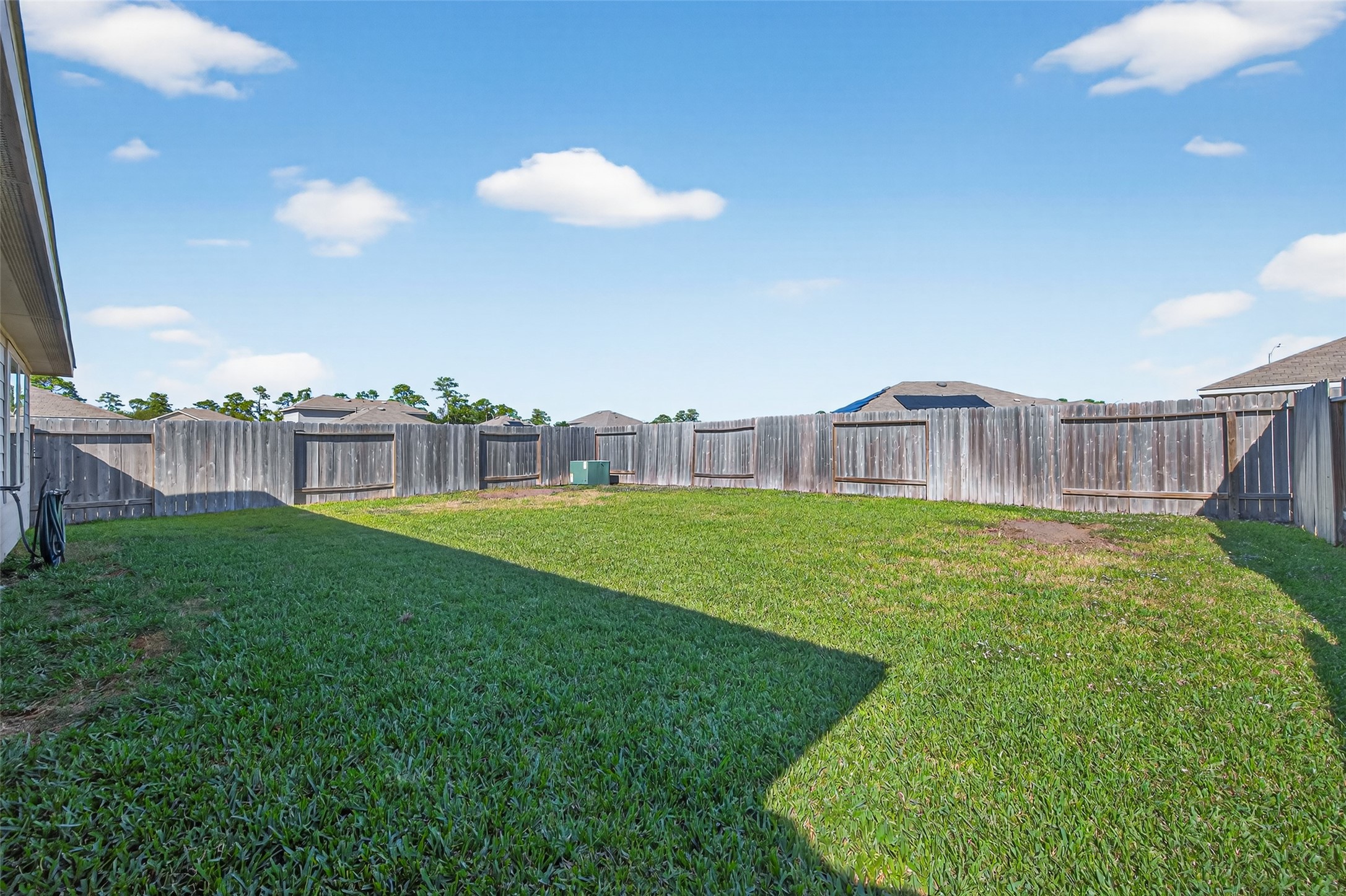 23706 Blodgett Peak Trail Spring, TX 77373 - Photo 24 of 31 Spacious backyard with well-maintained grass, enclosed by a wooden fence, offering privacy and ample space for outdoor activities.
