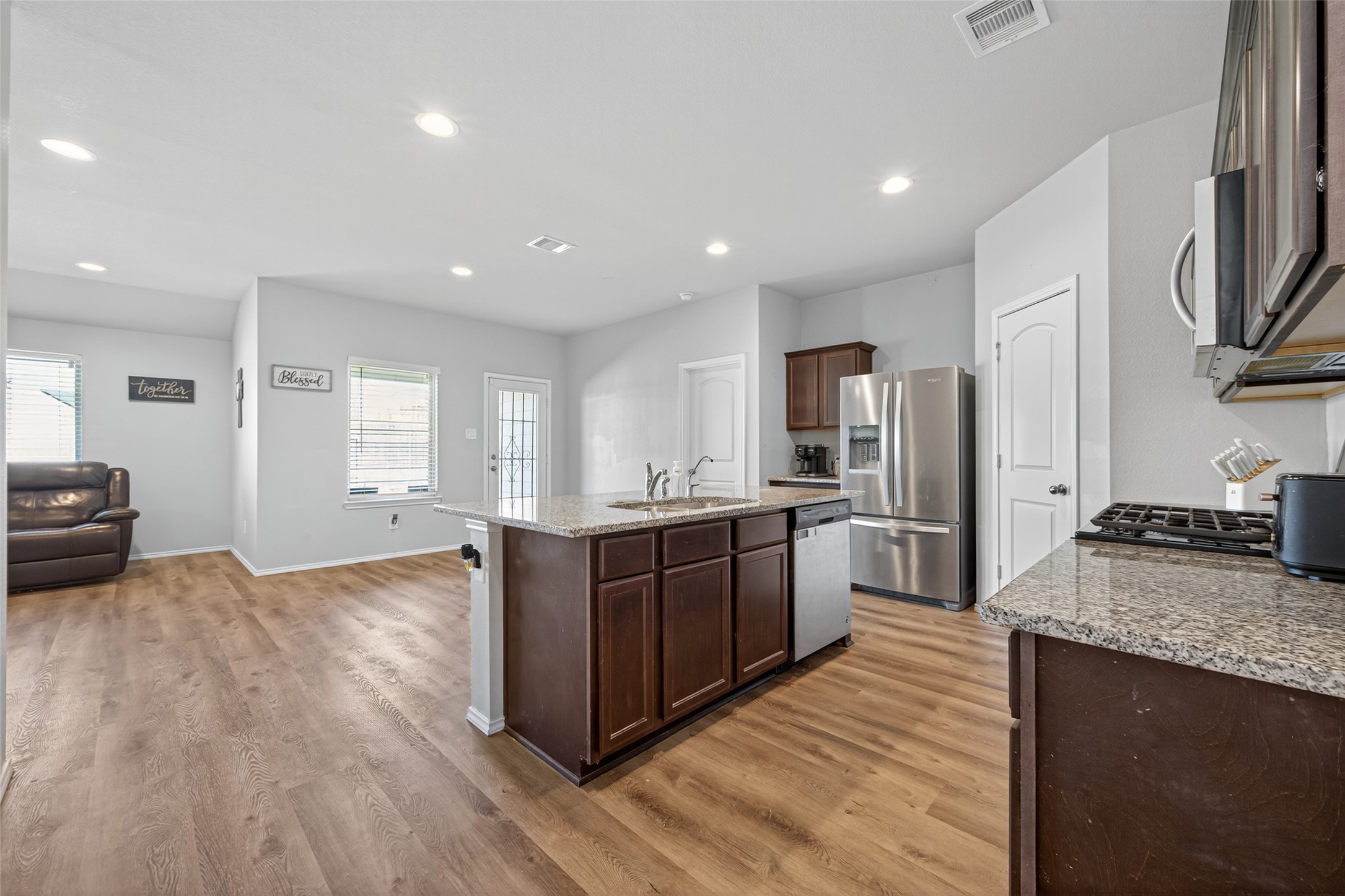 23706 Blodgett Peak Trail Spring, TX 77373 - Photo 7 of 31 a large kitchen with stainless steel appliances granite countertop a large counter top a stove a sink dishwasher and a refrigerator with wooden floor