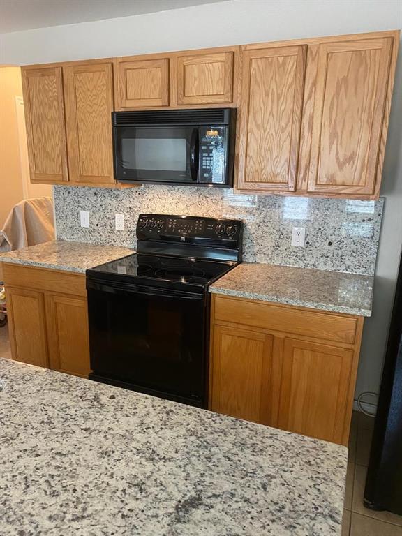10059 Wake Bridge Drive Frisco, TX 75035 - Photo 3 of 10 a kitchen with a sink a stove top oven and wooden cabinets