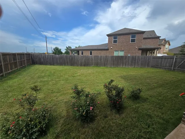 a view of a backyard with a plants and wooden fence
