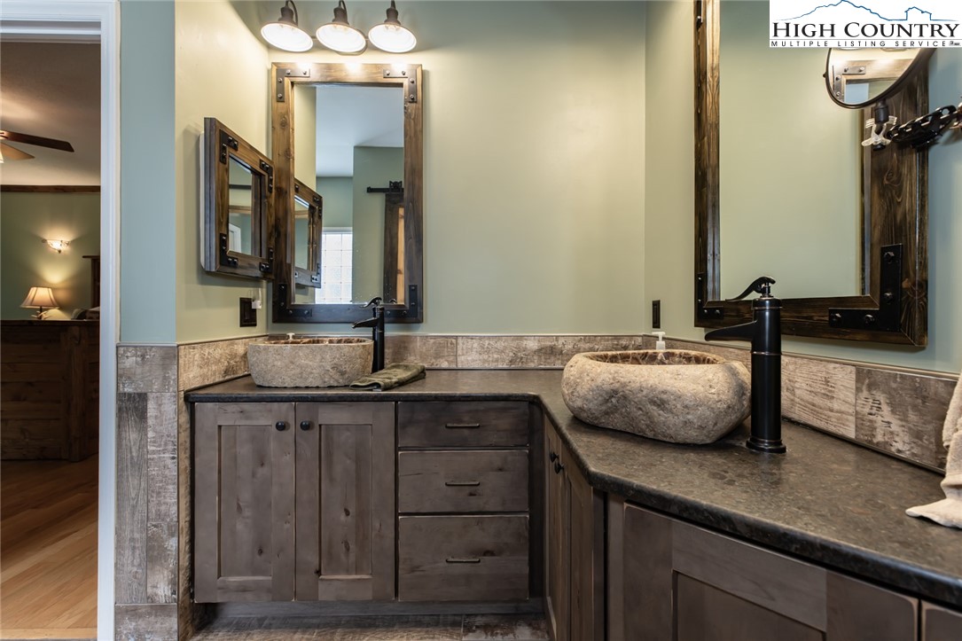 1328 Don Bare Road Jefferson, NC 28640 - Photo 27 of 49 a bathroom with a granite countertop sink and a mirror