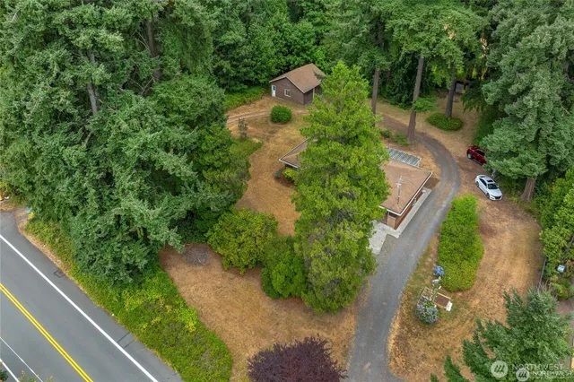 an aerial view of a house with a yard and greenery