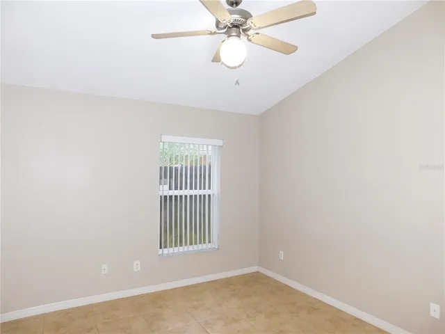 an empty room with a window and a fan