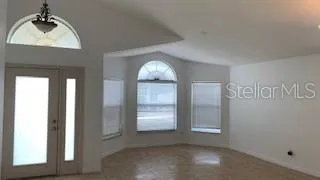 an empty room with windows and cabinet