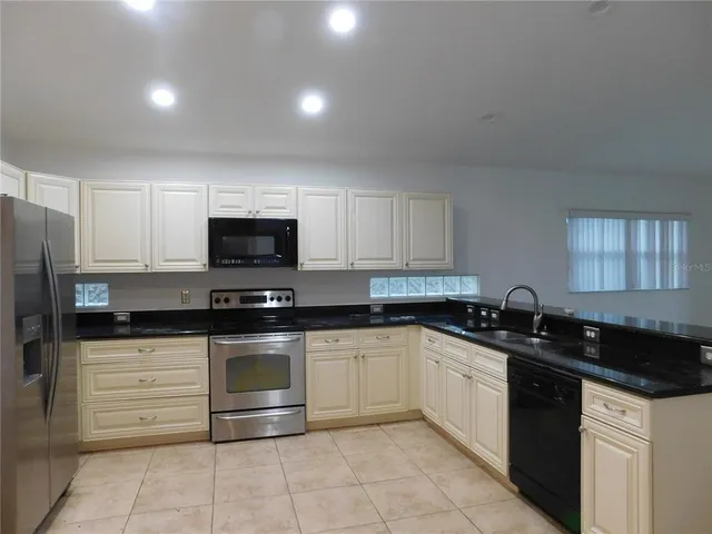 a kitchen with stainless steel appliances granite countertop a sink and a stove