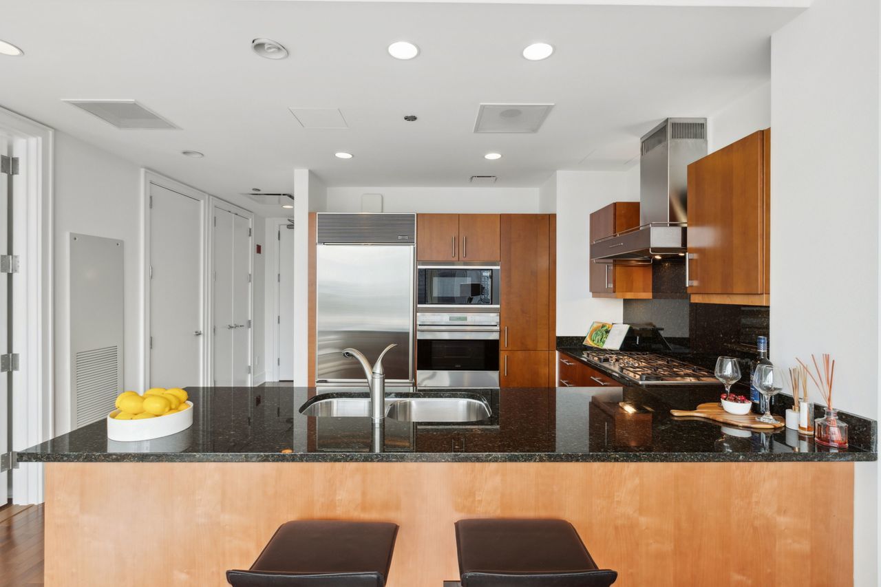 401 North Wabash Avenue, Unit 30I Chicago, IL 60611 - Photo 13 of 49 a kitchen with stainless steel appliances kitchen island granite countertop a refrigerator and a stove