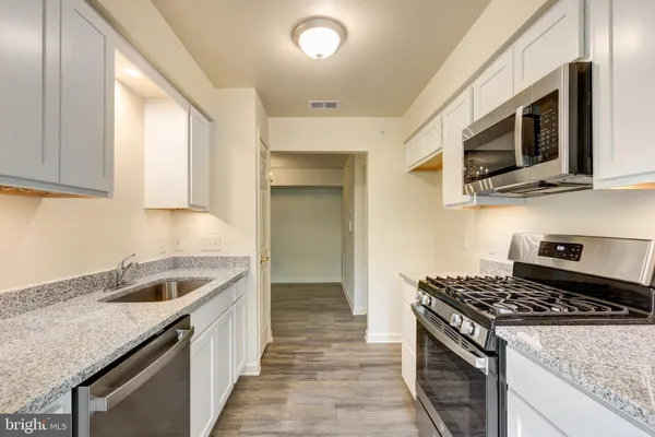 a kitchen with granite countertop a sink and steel appliances