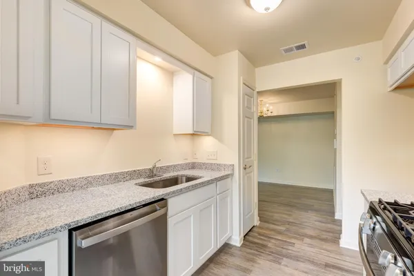 a kitchen with granite countertop a sink and a stove top oven