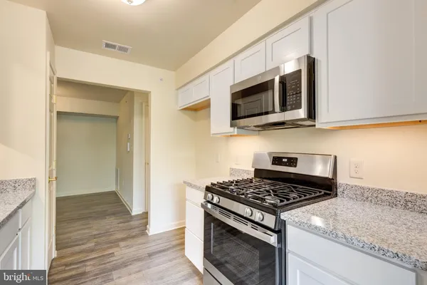 a kitchen with stainless steel appliances granite countertop a stove and a microwave