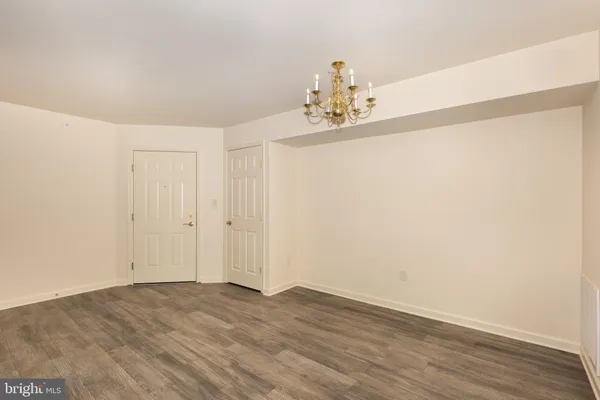 a view of a room with wooden floor and chandelier