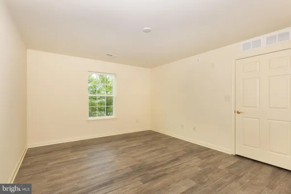 an empty room with wooden floor and window