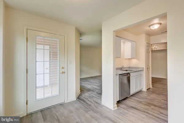 a kitchen with granite countertop white cabinets and stainless steel appliances