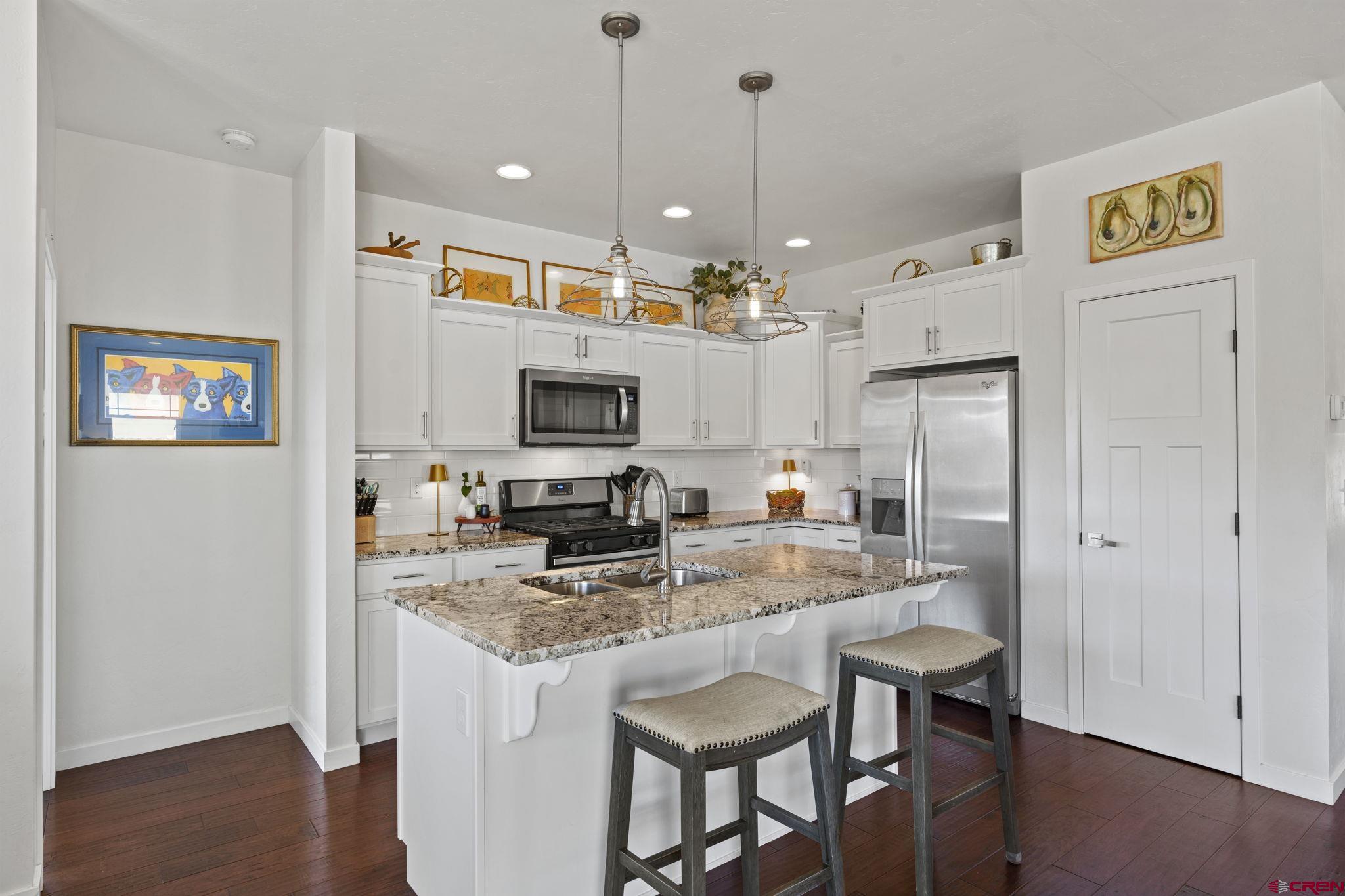 155 Prospector Avenue Durango, CO 81301 - Photo 6 of 35 a kitchen with stainless steel appliances granite countertop a refrigerator a sink a stove a dining table and chairs