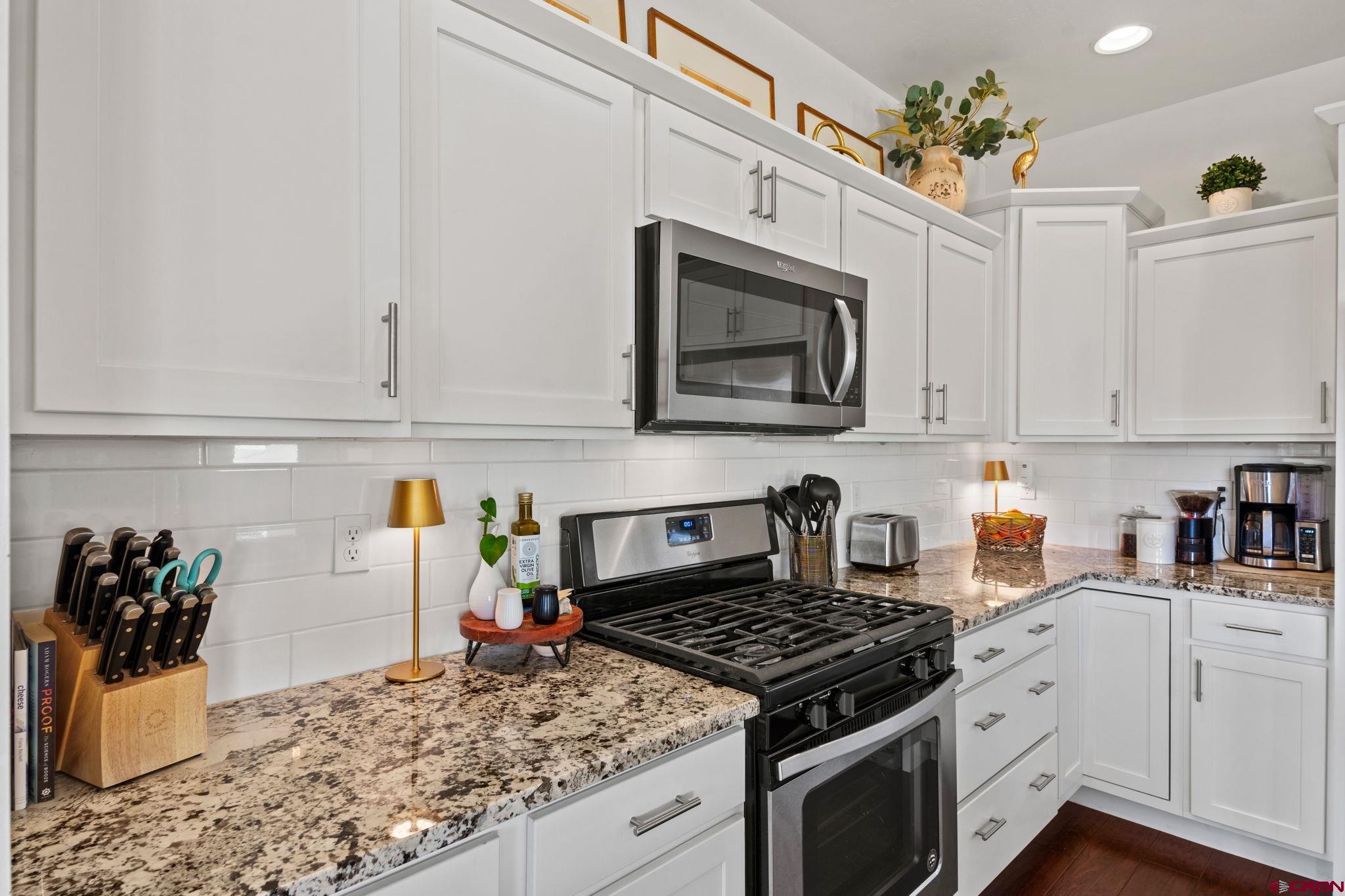 155 Prospector Avenue Durango, CO 81301 - Photo 7 of 35 a kitchen with white cabinets and appliances