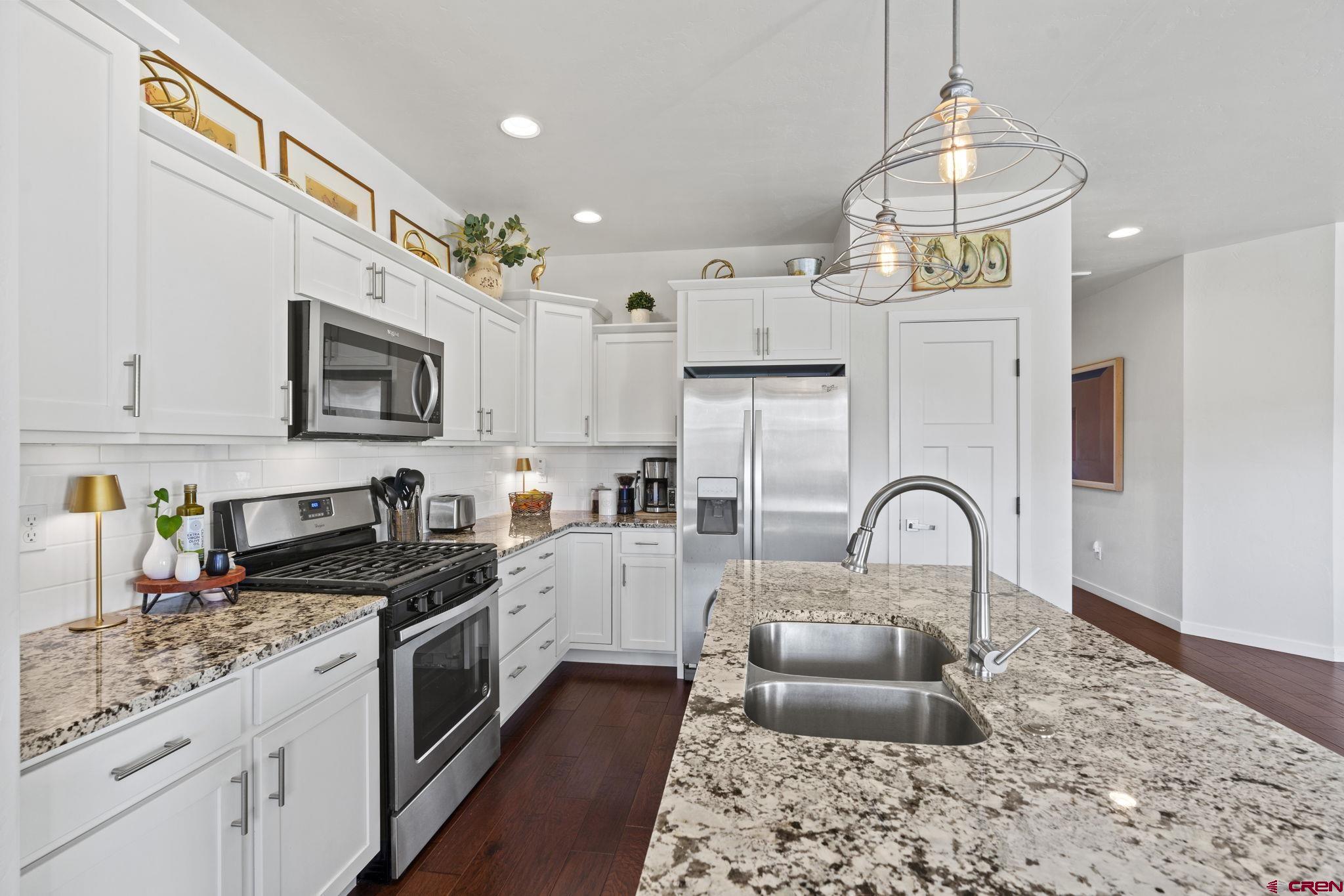 155 Prospector Avenue Durango, CO 81301 - Photo 8 of 35 a kitchen with stainless steel appliances granite countertop a sink a stove a refrigerator cabinets and living room view
