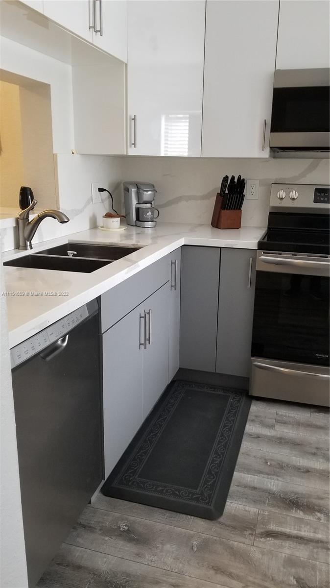 11368 Taft Street, Unit 11368 Pembroke Pines, FL 33026 - Photo 2 of 20 a kitchen with a sink stove and microwave