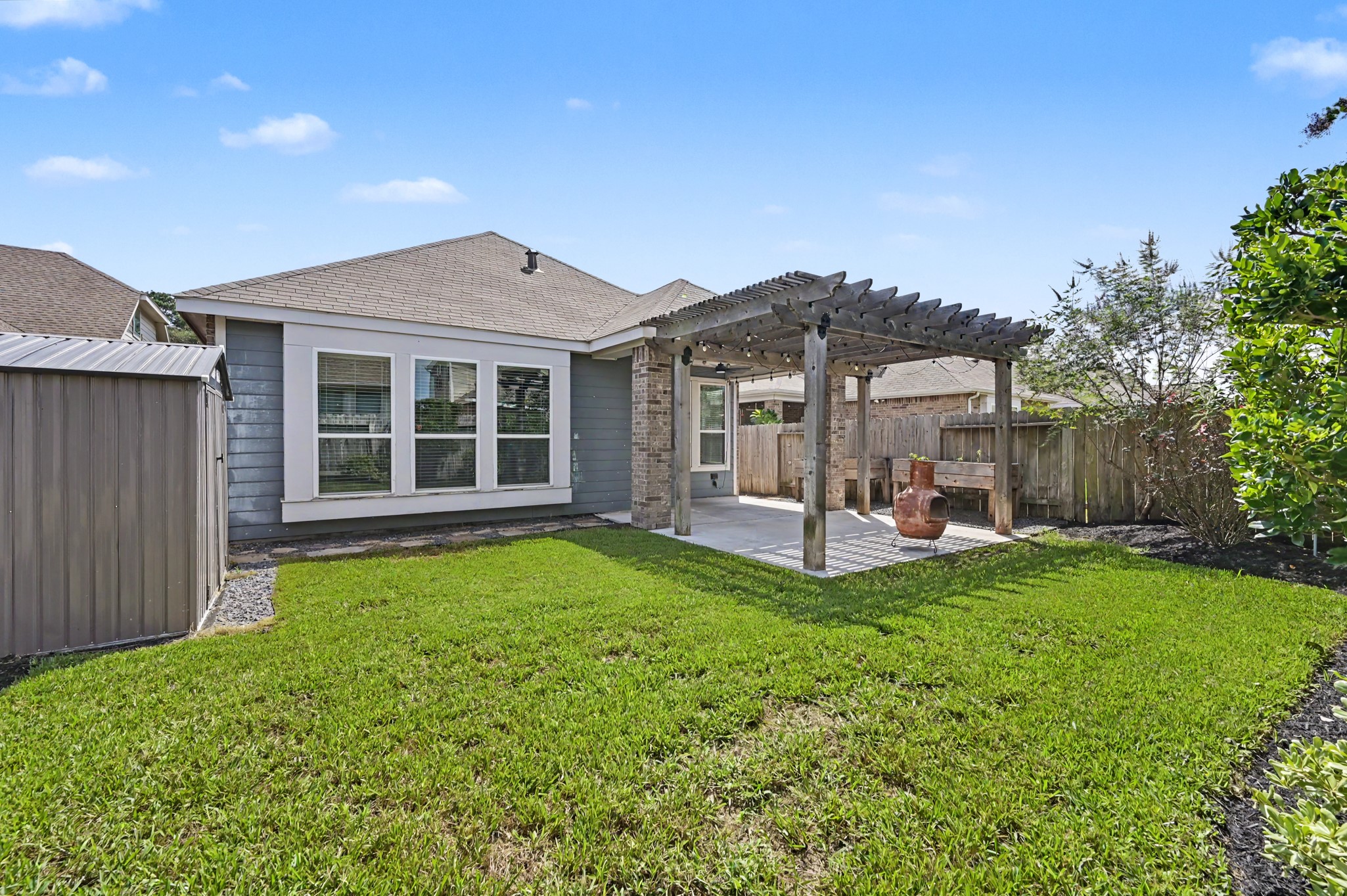 29836 Woodsons Edge Way Spring, TX 77386 - Photo 30 of 38 Alternate view of the backyard showing the extended patio, pergola, and storage shed.