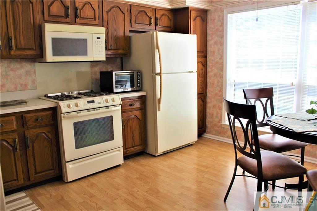 3904 Springbrook Drive, Unit 3904 Edison, NJ 08820 - Photo 11 of 25 a kitchen with furniture a refrigerator and a stove top oven