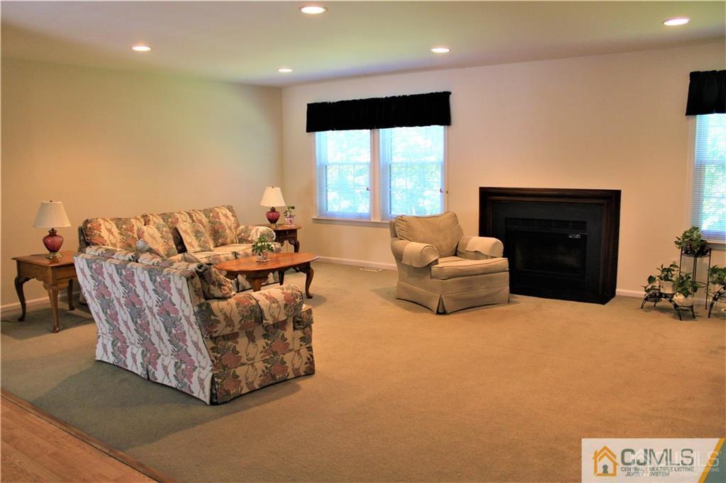 3904 Springbrook Drive, Unit 3904 Edison, NJ 08820 - Photo 5 of 25 a living room with furniture a flat screen tv and a large window