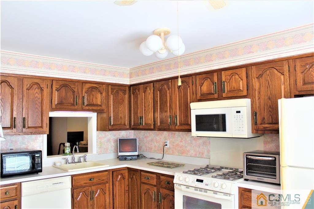 3904 Springbrook Drive, Unit 3904 Edison, NJ 08820 - Photo 10 of 25 a kitchen with stainless steel appliances granite countertop a stove top oven a sink dishwasher and a microwave oven with white cabinets