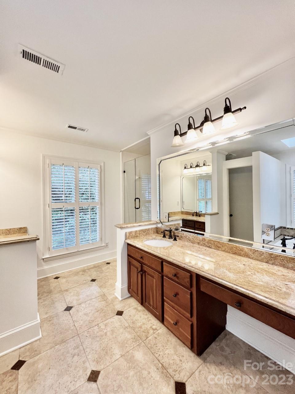 5614 Laurium Road Charlotte, NC 28226 - Photo 23 of 40 a spacious bathroom with a granite countertop sink and a large mirror