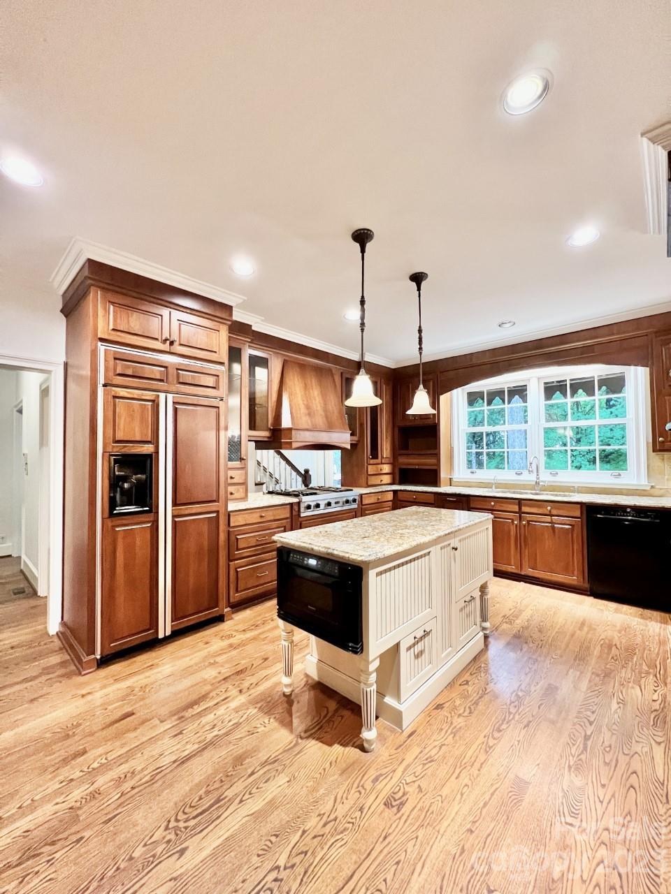 5614 Laurium Road Charlotte, NC 28226 - Photo 10 of 40 a large kitchen with kitchen island a large counter top a sink and stainless steel appliances