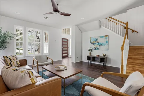 a living room with furniture ceiling fan and a window